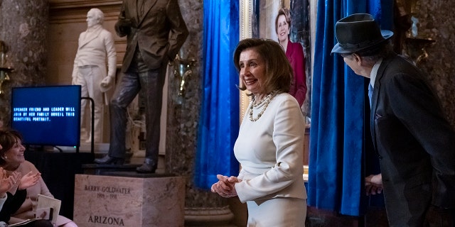 Die Sprecherin des Repräsentantenhauses, Nancy Pelosi, D-Calif., wird von ihrem Ehemann Paul Pelosi begleitet, als sie am Mittwoch, den 14. Dezember 2022, an der Enthüllung ihres Porträts in der Statuary Hall im Capitol in Washington teilnehmen. 