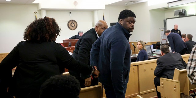 Adarius Carr, right, holds his sister Ashley Carr's hand as they leave the 396th Circuit Court after Aaron Dean was found guilty of manslaughter in the shooting death of Atatiana Jefferson, Thursday, Dec. 15, 2022, at the Tim Curry Criminal Justice Center in Fort Worth, Texas.