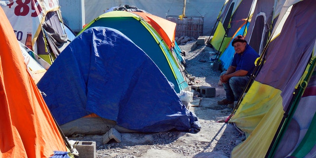 A migrant sits by his tent inside the Senda de Vida 2 shelter in Reynosa, Mexico, Thursday, Dec. 15, 2022. 