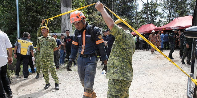 Rescue team gathered at a checkpoint near the site of a landslide on an organic farm in Batang Kali, Malaysia on Friday, December 16, 2022. Dozens of Malaysians are believed to have been at a tourist campsite in Batang Kali, outside the capital of Kuala Lumpur, when the incident happened, a district police chief said.