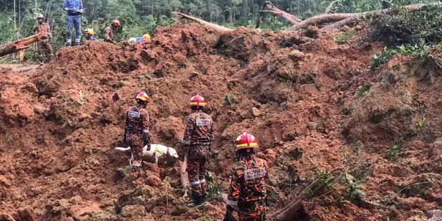In this photo released by Korporat JBPM, rescuers work at a campsite following a landslide, in Batang Kali, Selangor state, on the outskirts of Kuala Lumpur, Malaysia, Dec. 16, 2022. A landslide occurred at a tourist campsite in Malaysia on Friday it left more Over a dozen people died and authorities said a dozen more people were buried at the site on an organic farm outside the capital of Kuala Lumpur.