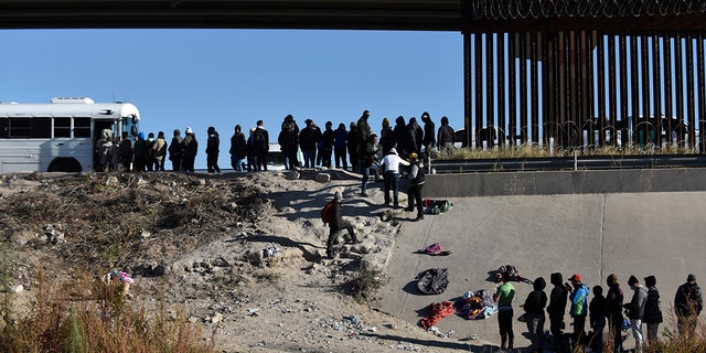 Migrants wait to get into a U.S. government bus after crossing the border from Ciudad Juarez, Mexico, to El Paso, Texas on Monday.