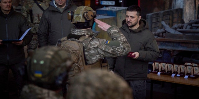 Ukrainian President Volodymyr Zelenskyy, right, awards a serviceman at the site of the heaviest battles with the Russian invaders in Bakhmut, Ukraine, Dec. 20, 2022.