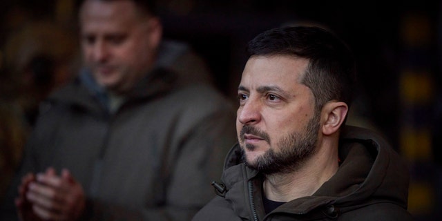 Ukrainian President Volodymyr Zelenskyy looks on as he meets soldiers at the site of the heaviest battles with the Russian invaders in Bakhmut, Ukraine, Dec. 20, 2022.