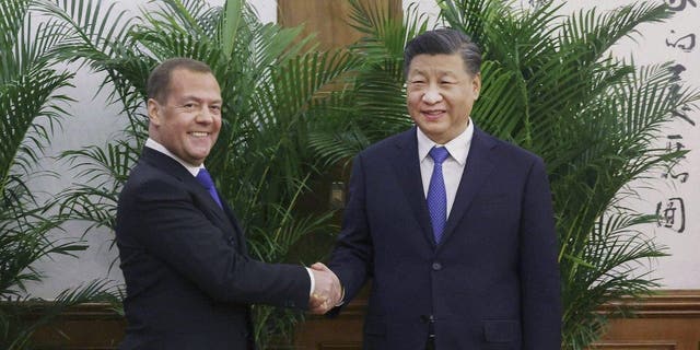 Deputy head of Russia's Security Council and chairman of the United Russia Party, Dmitry Medvedev, left, shakes hands with Chinese President Xi Jinping before their meeting in Beijing, Wednesday, Dec. 21, 2022. 