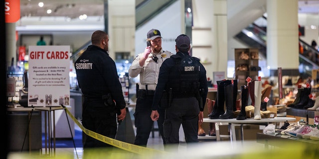 Security officers speak inside a store at the Mall of America in Bloomington, Minn., after reports of shots fired on Friday, Dec. 23, 2022. 
