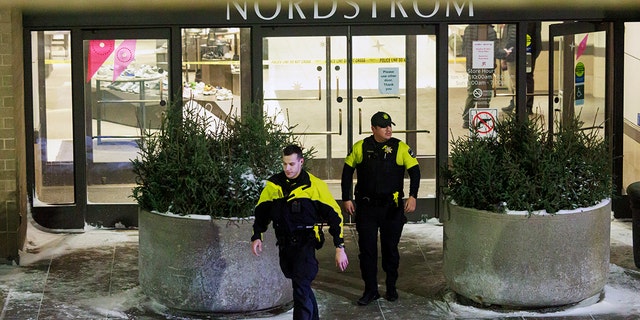 Two officers walk out of Nordstrom in Mall of America in Bloomington, Minn., after a shooting on Friday, Dec. 23, 2022. 