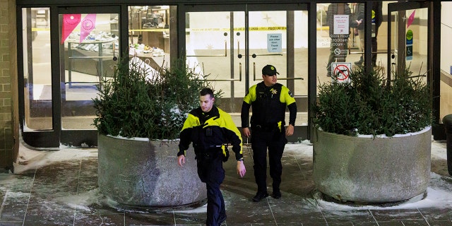 Two officers walk out of Nordstrom in Mall of America in Bloomington, Minn., after a shooting on Friday, Dec. 23, 2022. 