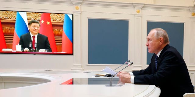 Russian President Vladimir Putin, right, speaks during a meeting with Chinese President Xi Jinping via a video conference at the Kremlin in Moscow Friday, Dec. 30, 2022.