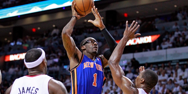 New York Knicks forward Amar'e Stoudemire shoots between Heat defenders Chris Bosh and LeBron James during the Eastern Conference playoff in Miami, Florida, April 30, 2012.