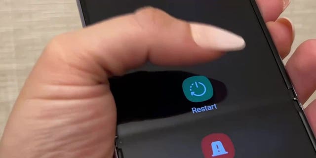 Foto einer Frau, die ihr Android-Smartphone neu startet.