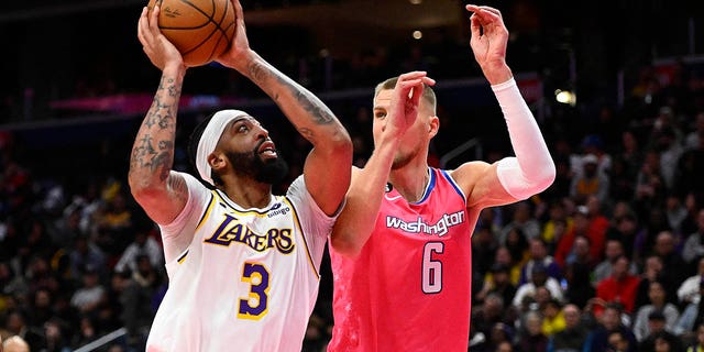 Dec 4, 2022; Washington, District of Columbia, USA; Los Angeles Lakers forward Anthony Davis (3) shoots as Washington Wizards center Kristaps Porzingis (6) defends during the second half at Capital One Arena.