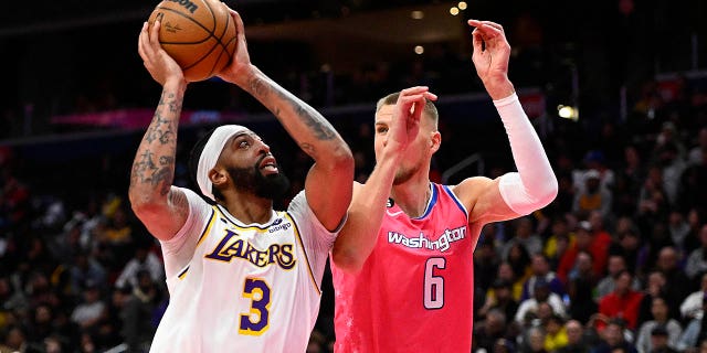 Dec 4, 2022; Washington, District of Columbia, USA; Los Angeles Lakers forward Anthony Davis (3) shoots as Washington Wizards center Kristaps Porzingis (6) defends during the second half at Capital One Arena.