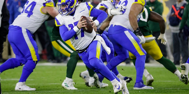 Los Angeles Rams quarterback Baker Mayfield (17) rolls out to pass against the Green Bay Packers in the first half of an NFL football game in Green Bay, Wis. Monday, Dec. 19, 2022.