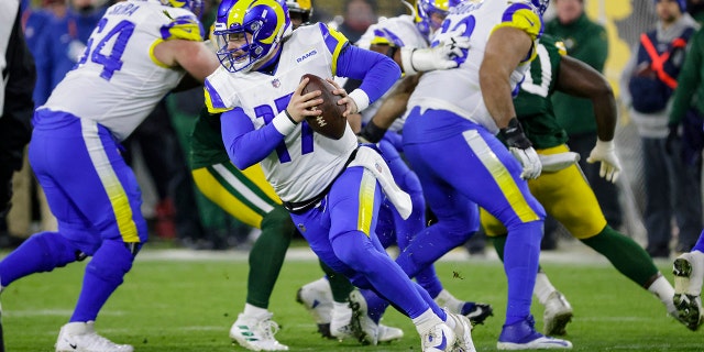 Los Angeles Rams quarterback Baker Mayfield (17) rolls out to pass against the Green Bay Packers in the first half of an NFL football game in Green Bay, Wis. Monday, Dec. 19, 2022.