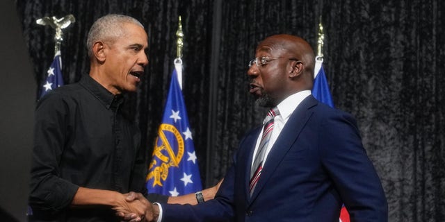 Sen. Raphael Warnock, D-Ga., right, shakes hands with former President Barack Obama during a rally on Thursday, Dec. 1, 2022, in Atlanta. Warnock is running against Republican Herschel Walker in a runoff election. 