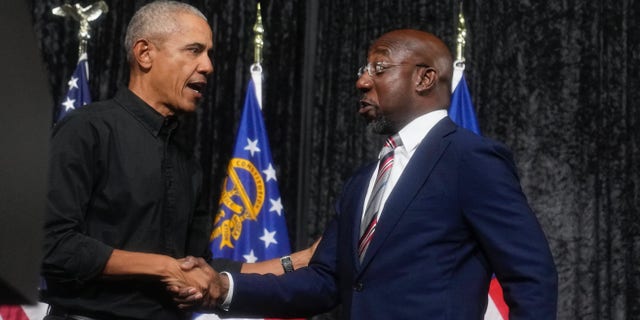 Sen. Raphael Warnock, D-Ga., right, shakes hands with former President Barack Obama during a rally on Thursday, Dec. 1, 2022, in Atlanta. Warnock is running against Republican Herschel Walker in a runoff election. 