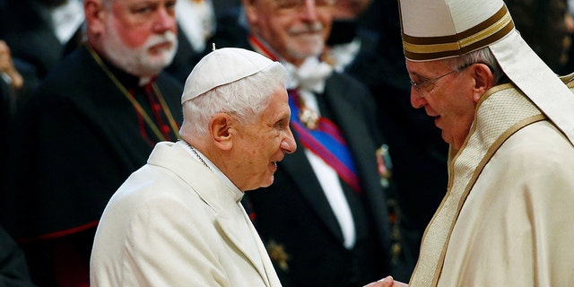 FILE- Pope Francis greets Pope Emeritus Benedict XVI during a mass to create 20 new cardinals during a ceremony in St. Peter's Basilica at the Vatican Feb. 14, 2015.