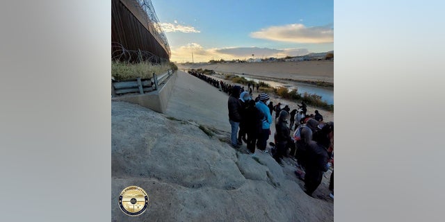 Migrants stand across the Rio Grande from El Paso, Texas.  Thousands of migrants have illegally crossed into the city in recent days, prompting concerns from city officials.  Texas Gov.  Greg Abbott wants nongovernmental organizations (NGOs) investigated over their role is assisting migrants to illegally cross the border.