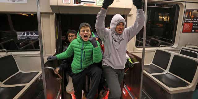 Tufts students cheer as they step onto the Green Line Extension's Medford branch train, on Dec. 12, 2022. The $2.3 billion Green Line extension is anticipated to give commuters as far as Tufts University an easier ride into downtown Boston. 