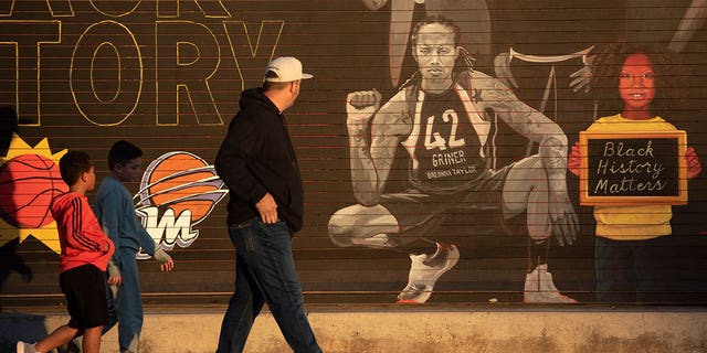People walk past a mural of Brittney Griner outside the Footprint Center in Phoenix Dec. 8, 2022. 