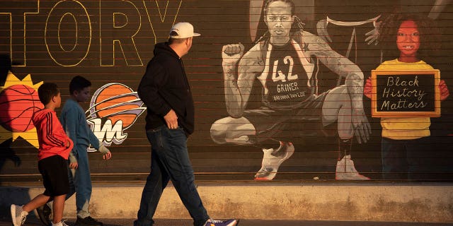 People walk past a mural of Brittney Griner outside the Footprint Center in Phoenix Dec. 8, 2022.
