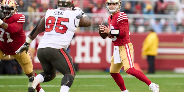 Brock Purdy #13 of the San Francisco 49ers runs back for a pass against the Tampa Bay Buccaneers during halftime at Levi's Stadium on December 11, 2022, in Santa Clara, California. 