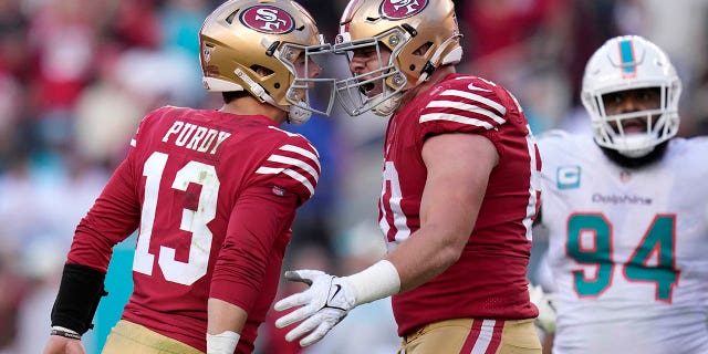 Le quart-arrière des 49ers de San Francisco Brock Purdy, n ° 13, célèbre après avoir lancé une passe de touché au porteur de ballon Christian McCaffrey avec le plaqueur offensif Daniel Brunskill, au milieu, alors que le plaqueur défensif des Dolphins de Miami Christian Wilkins, n ° 94, réagit au cours de la première moitié d'un match de football de la NFL à Santa Clara, Californie, dimanche 4 décembre 2022. 