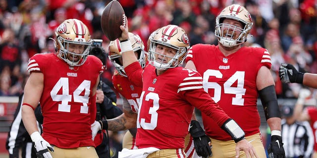 San Francisco 49ers quarterback Brock Purdy (13) celebrates with teammates after running for a touchdown against the Tampa Bay Buccaneers during the first half of an NFL football game in Santa Clara, California on Sunday, December 11, 2022. 