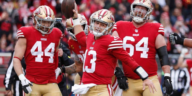 San Francisco 49ers quarterback Brock Purdy (13) celebrates with teammates after running for a touchdown against the Tampa Bay Buccaneers during the first half of an NFL football game in Santa Clara, California on Sunday, December 11, 2022. 