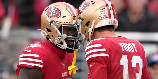 San Francisco 49ers quarterback Brock Purdy (13) is congratulated by wide receiver Deebo Samuel after scoring a touchdown against the Tampa Bay Buccaneers during the first half in Santa Clara, California, Sunday, Dec. 11, 2022.