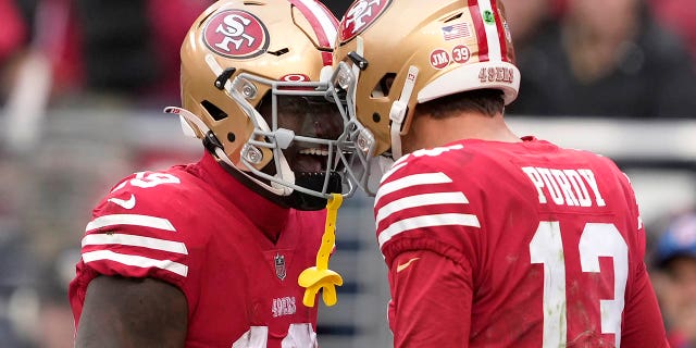 San Francisco 49ers quarterback Brock Purdy (13) is congratulated by wide receiver Deebo Samuel after scoring a touchdown against the Tampa Bay Buccaneers during the first half in Santa Clara, California, Sunday, Dec. 11, 2022.