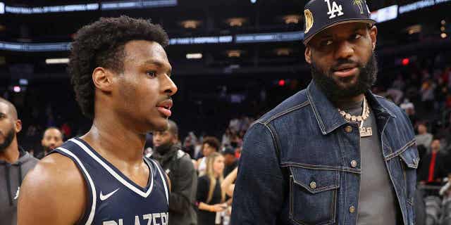 Bronny James stands with his father, LeBron James, following a Sierra Canyon Trailblazers game n Phoenix on Dec. 11, 2021.