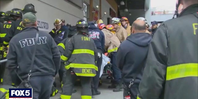 A victim was placed on a stretcher after being pulled from a Bronx elevator shaft.