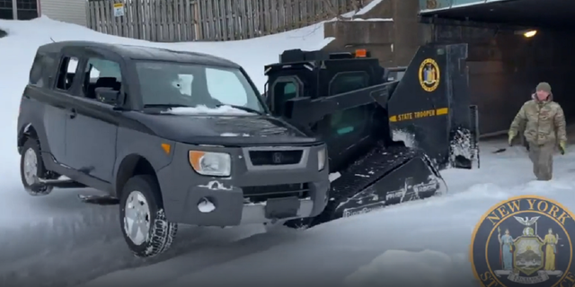 The New York State Police Rook vehicle moves an SUV along a street in Buffalo, New York.