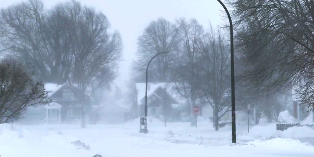 The high wind blows the snow across a neighborhood in Buffalo, New York, on Saturday, Dec. 24, 2022. A battering winter storm has knocked out power to 1.7 million homes and businesses across the United States on Saturday. Gov. Kathy Hochul said Saturday that the Buffalo Niagara International Airport will be closed through Monday morning, some roads would be closed through Christmas Day and almost every fire truck in Buffalo was stranded in the snow.