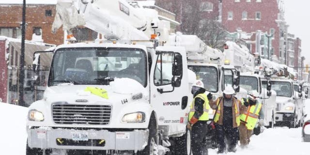 Power line trucks arrive on Allen Street to supply power to apartments and homes in Buffalo, N.Y., on Monday, Dec. 26, 2022. Many people lost power where they live due to the recent blizzard. 
