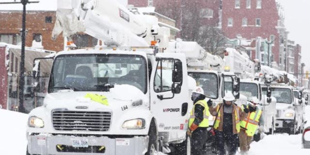 Power line trucks arrive on Allen Street to supply power to apartments and homes in Buffalo, N.Y., on Monday, Dec. 26, 2022. Many people lost power where they live due to the recent blizzard.