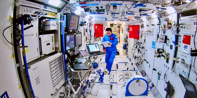 This photo taken and released on August 20, 2021, by China Manned Space Engineering Office via CNS shows Chinese astronaut Tang Hongbo coordinating inside the Tianhe core module as his colleague Nie Haisheng conducts a spacewalk.