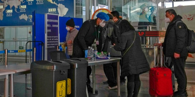 Passengers wearing face masks line up for security check before entering an international departure gate at the Beijing Capital International Airport in Beijing, Thursday, Dec. 29, 2022. Moves by the U.S., Japan and others to mandate COVID-19 tests for passengers arriving from China reflect global concern that new variants could emerge in its ongoing explosive outbreak — and the government may not inform the rest of the world quickly enough. 