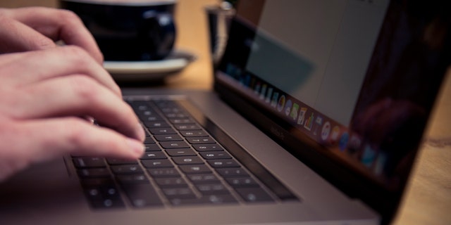 Detail seseorang mengetik di keyboard komputer laptop Apple MacBook Pro di kafe, diambil pada 18 November 2016. 