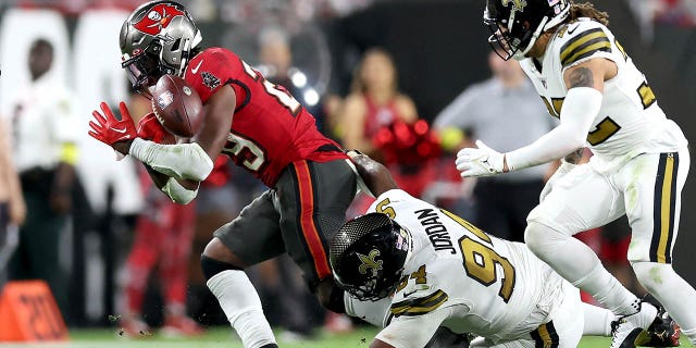 Buccaneers' Rachaad White fumbles the ball against Cameron Jordan of the New Orleans Saints at Raymond James Stadium on Dec. 5, 2022, in Tampa, Florida.