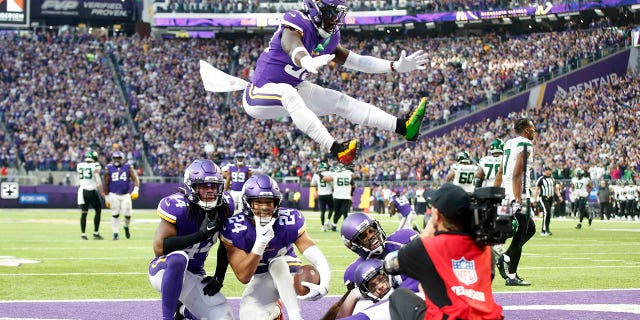 Minnesota Vikings safety Camryn Bynum (24) celebrates with teammates after intercepting a pass during the second half of an NFL football game against the New York Jets, Sunday, Dec. 4, 2022, in Minneapolis.