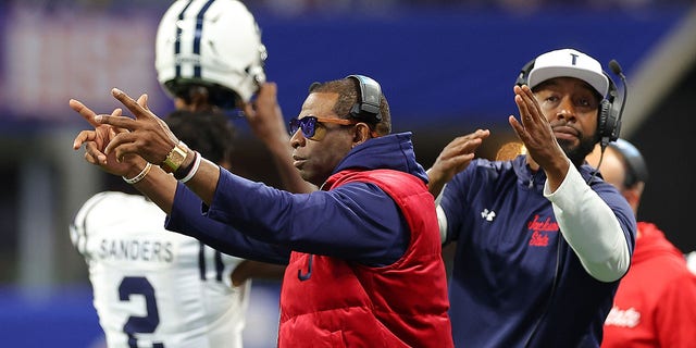 Head coach Deion Sanders and next Jackson State Tigers head coach TC Taylor work on the sidelines against the North Carolina Central Eagles during the first half of the Cricket Celebration Bowl at Mercedes-Benz Stadium on December 17, 2022 in Atlanta, Georgia.