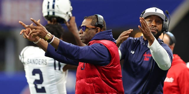 Head coach Deion Sanders and T.C. Taylor, the next head coach of the Jackson State Tigers, work the sideline against the North Carolina Central Eagles during the first half of the Cricket Celebration Bowl at Mercedes-Benz Stadium on December 17, 2022 in Atlanta, Georgia.