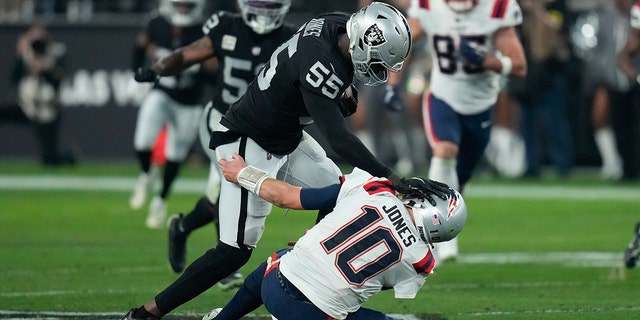 Las Vegas Raiders defensive end Chandler Jones (55) breaks a tackle by New England Patriots quarterback Mac Jones (10) to score a touchdown on an interception during the second half of an NFL football game between the New England Patriots and Las Vegas Raiders, Sunday, Dec. 18, 2022, in Las Vegas.