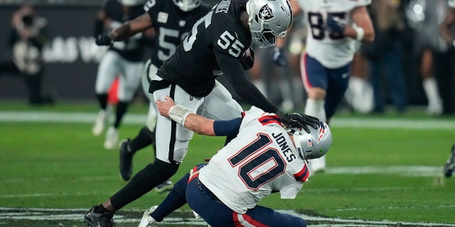 Las Vegas Raiders defensive end Chandler Jones (55) breaks a tackle by New England Patriots quarterback Mac Jones (10) to score a touchdown on an interception during the second half of an NFL football game between the New England Patriots and Las Vegas Raiders, Sunday, Dec. 18, 2022, in Las Vegas.