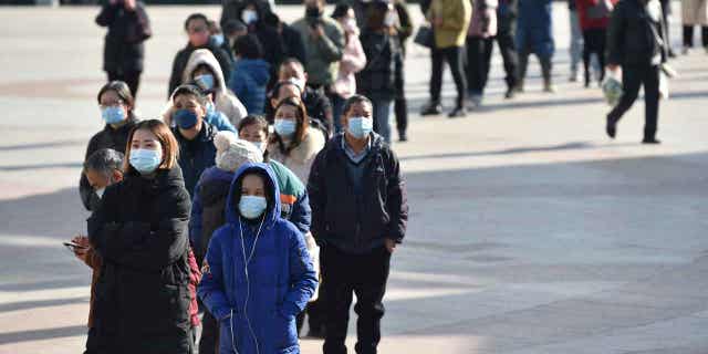 Inwoners staan ​​op 15 december 2022 in Nanjing, in de provincie Jiangsu, China, in de rij voor een apotheek om antigeentestkits voor het coronavirus te kopen. 