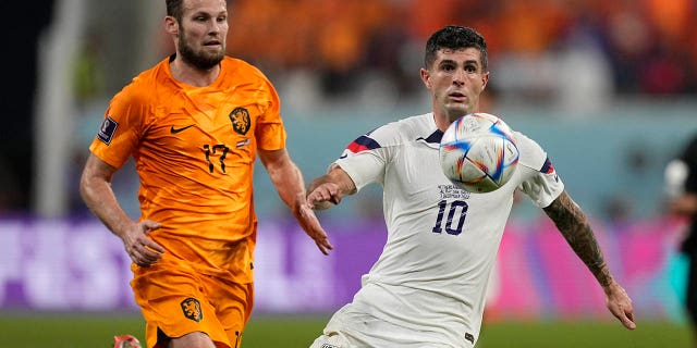 Christian Pulisic of the United States, right, goes for the ball Daley Blind of the Netherlands follows him during the World Cup round of 16 soccer match between the Netherlands and the United States, at the Khalifa International Stadium in Doha, Qatar, Saturday, Dec. 3, 2022.