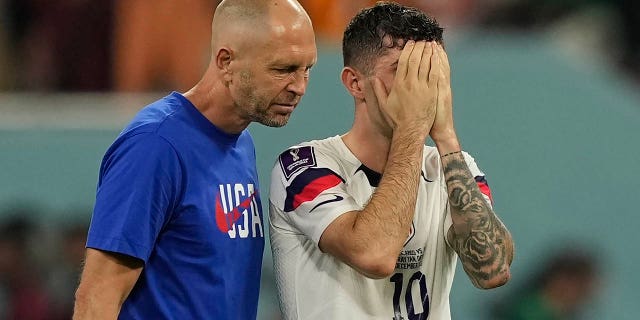 Head coach Gregg Berhalter of the United States, left, walks with Christian Pulisic after the World Cup round of 16 soccer match between the Netherlands and the United States, at the Khalifa International Stadium in Doha, Qatar, Saturday, Dec. 3, 2022.
